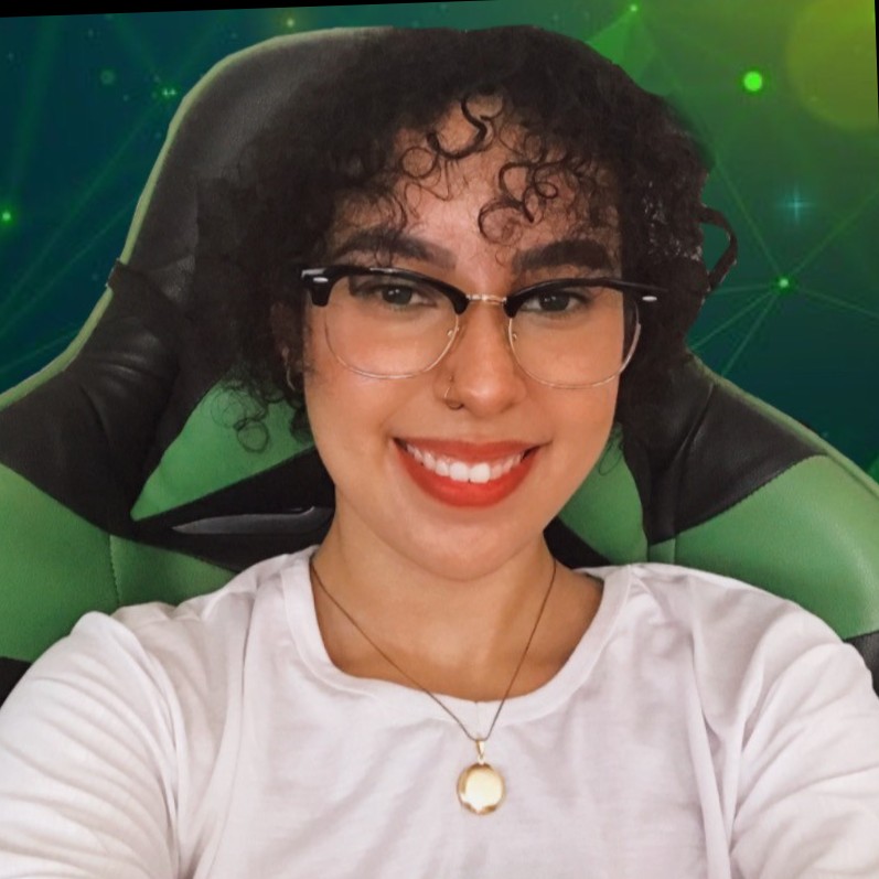 A picture of Mariana, a girl with short curly hair, tan skin and glasses, with a white shirt, orange lipstick and a necklace. She's sitting on a green chair with an edited green background and smiling.